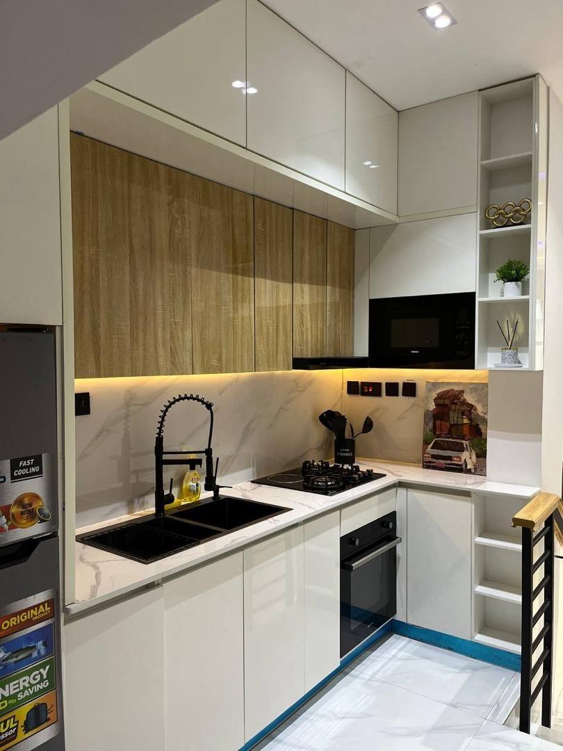 L-shaped kitchen with oak and white cabinetry, black sink and tap, and under-cabinet lighting
