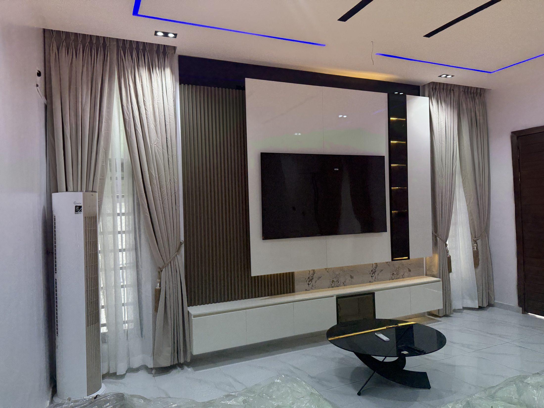 Living room media wall with white gloss panels, a dark timber-slatted side panel, a lit black glass display niche and a floating white unit with marble-effect splashback