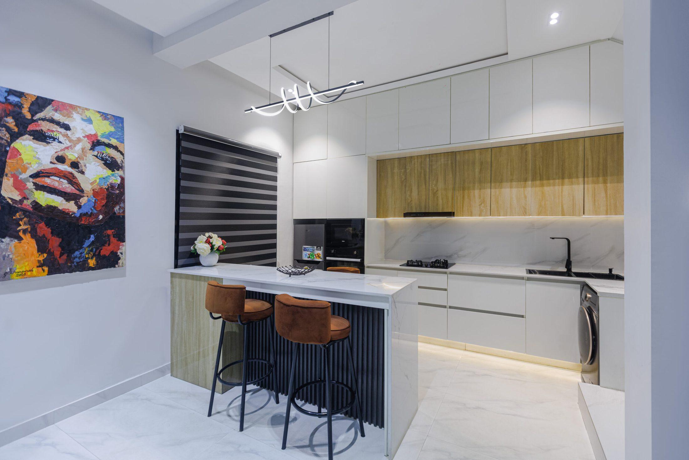 Kitchen with marble-effect island, rust bar stools, oak upper cabinets and a statement pendant light